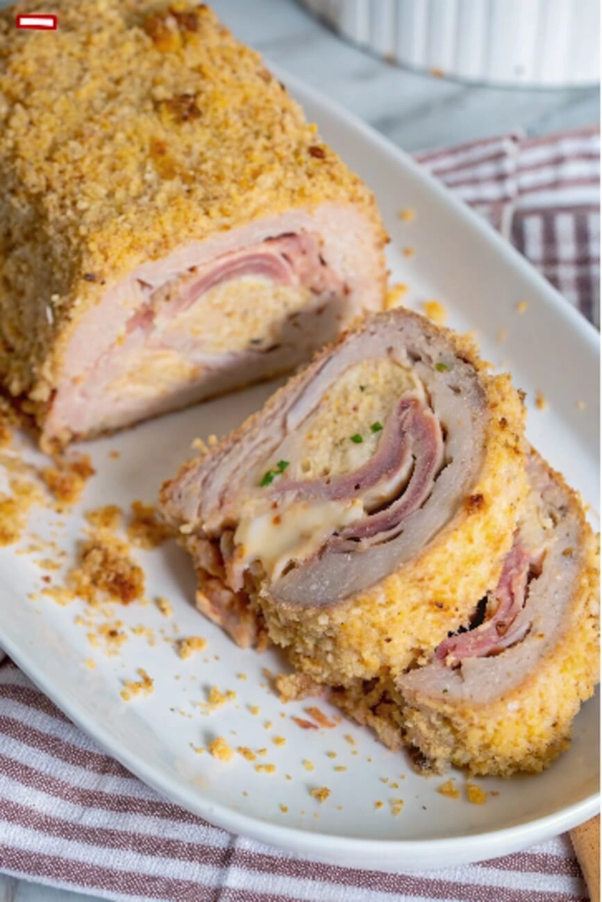 Chicken meatloaf roll cut in half showing spiral ham and cheese interior