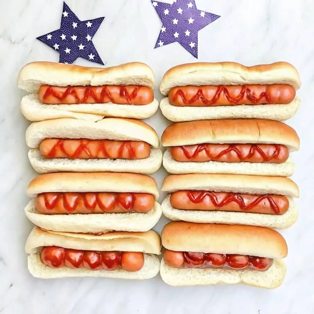 Two columns of four hot dogs each, topped with wavy red sauce, set against two blue stars with white dots.