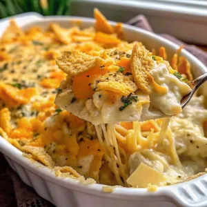 Close up of a cheesy Ritz chicken casserole on a spoon showing a long melted cheese pull and crispy cracker topping.
