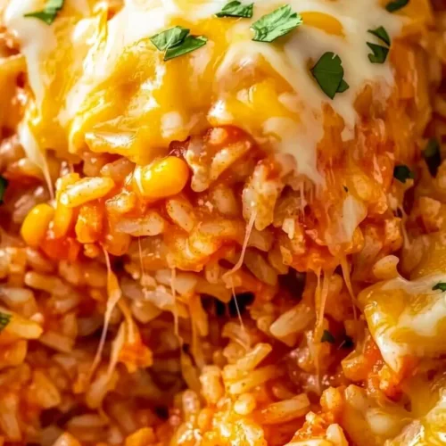 Macro close up of cheesy chicken fiesta rice bake with stretching melted cheese and sweet corn.